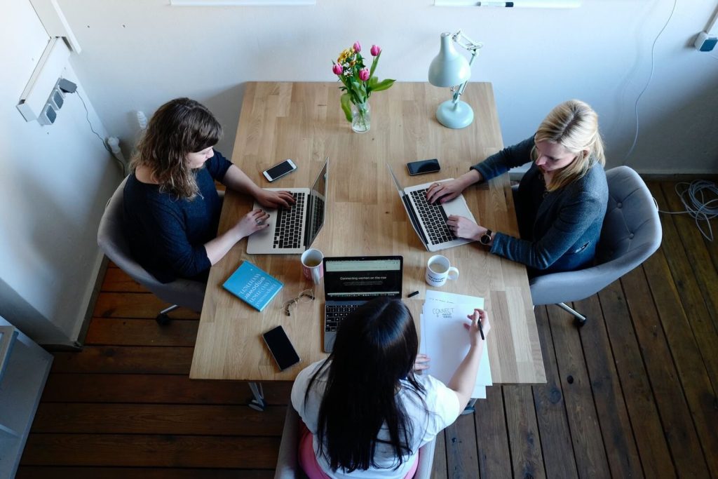 Top view of professionals working independently on laptops during a focused planning session