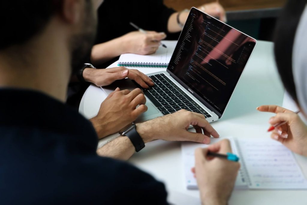 Professionals reviewing digital data and notes during a focused technical discussion